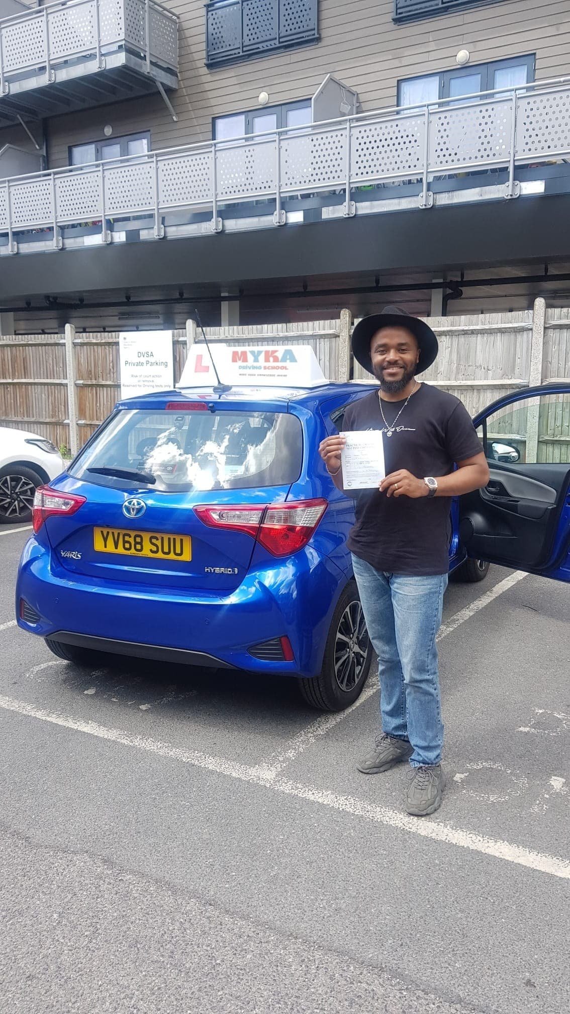 a man standing next to a blue car