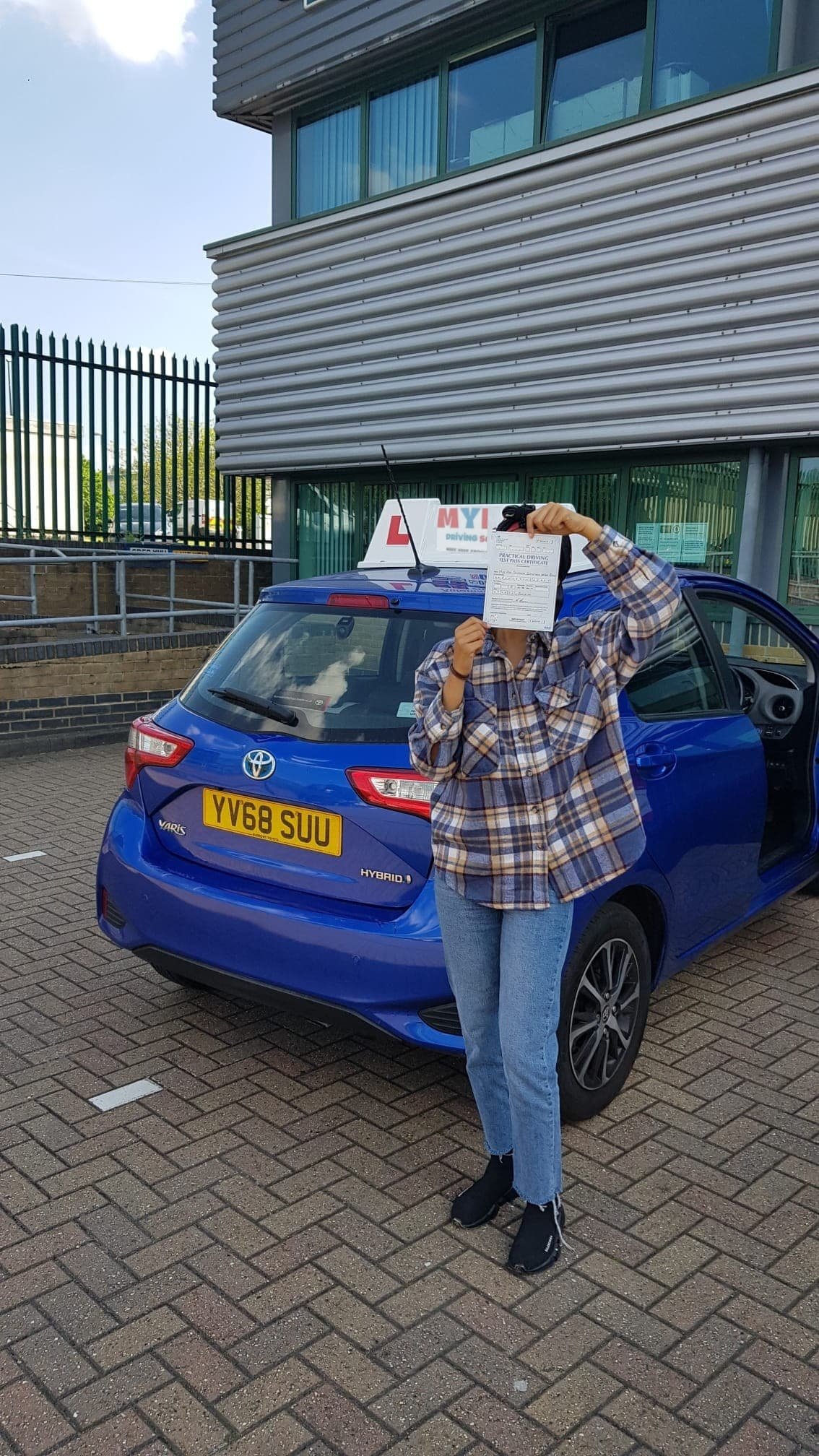 a person holding a paper in front of a car